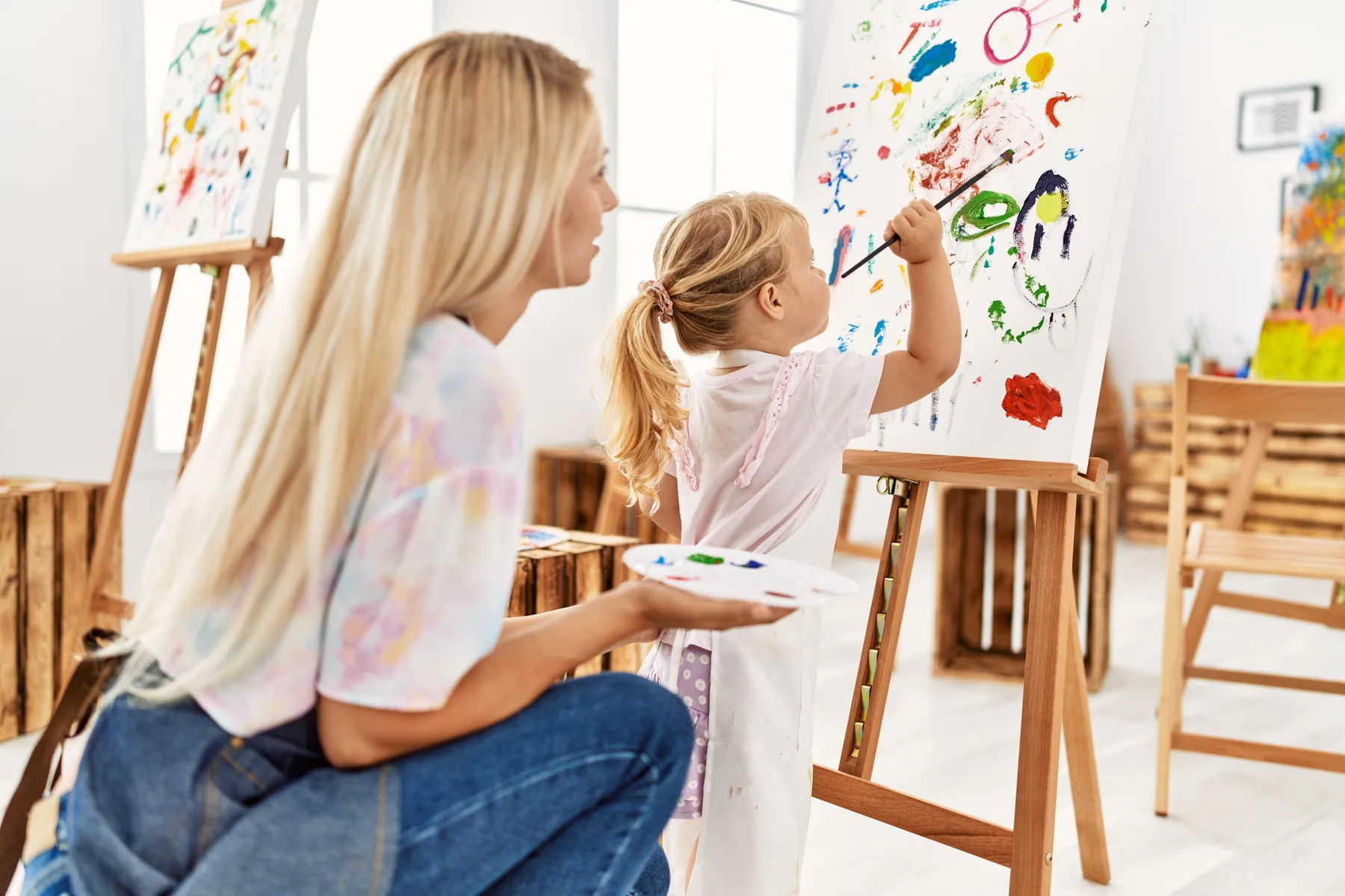 Madre e hija pintando juntas en un taller de arte